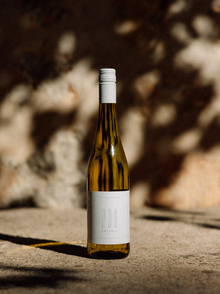 III Freunde Weissburgunder Weisswein Flasche vor Mauer