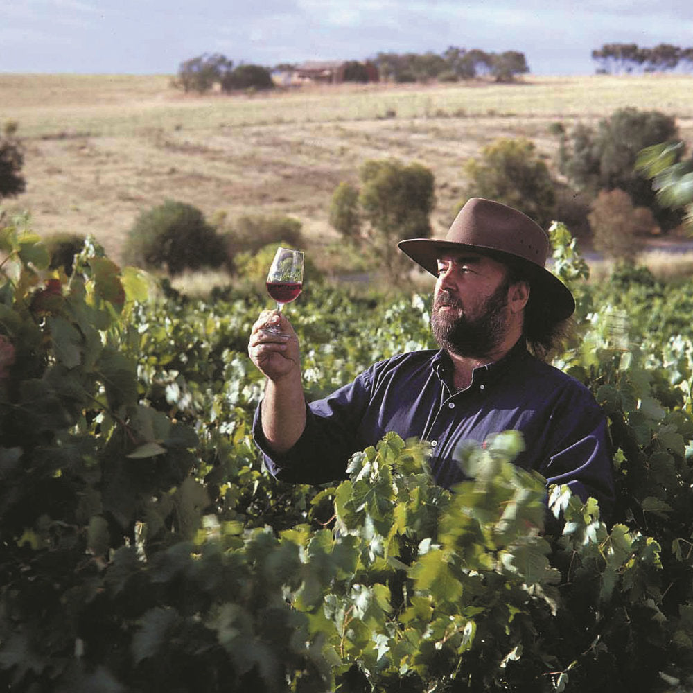 Simon Hackett mit Rotweinglas in seinen Weinbergen