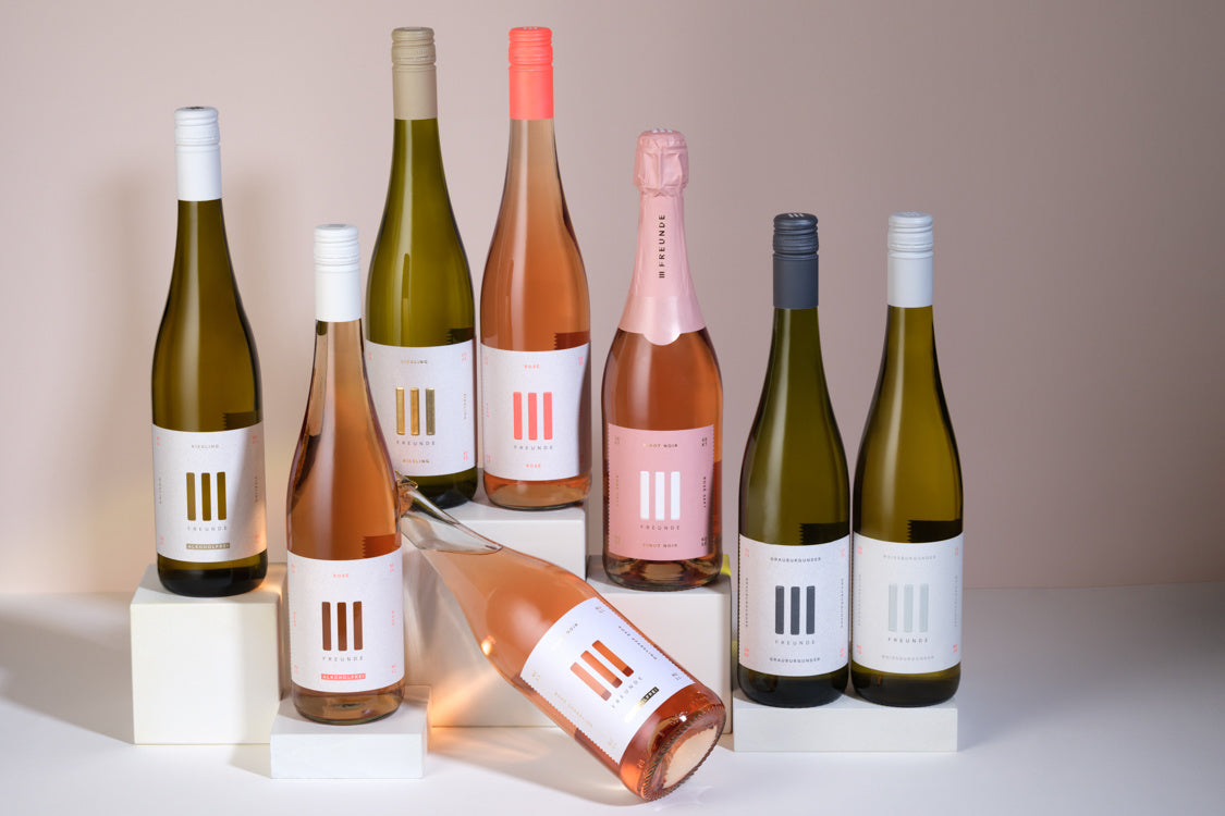 Verschiedene Flaschen III Freunde Wein vor beigen Hintergrund