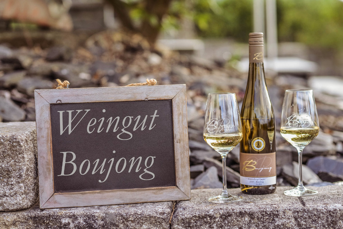 Weingut Boujong Kategoriebild eine Flasche Boujong Wein und 2 Weingläser auf Steinmauer