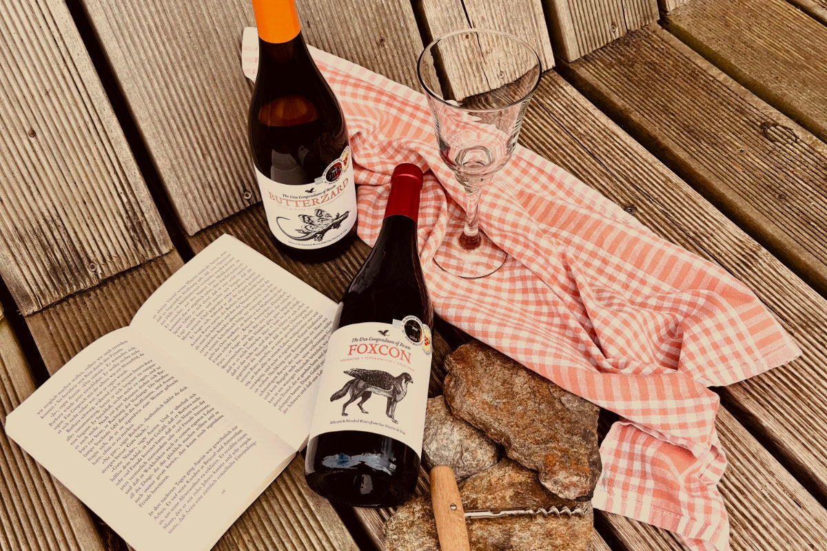 Kategoriebild Wein nach Anlass 2 Flaschen Wein auf Holzbank mit Buch und Korkenzieher
